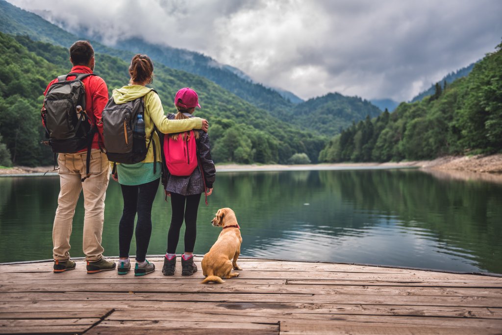 Une famille et leur chien sur le bord d'un lac