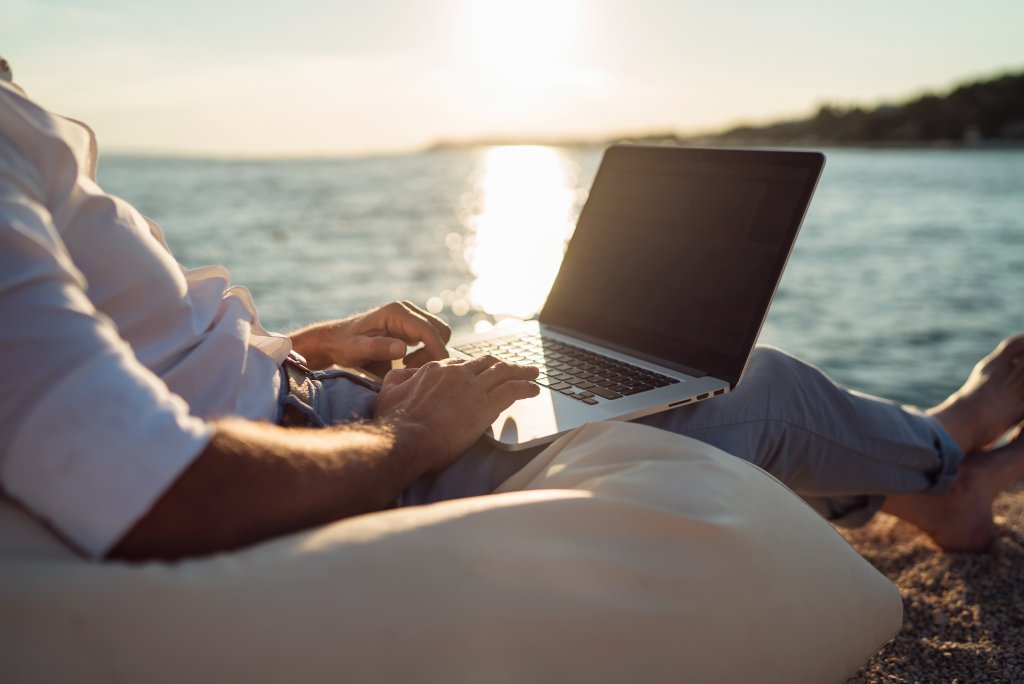 Une personne sur la plage avec son ordinateur portable